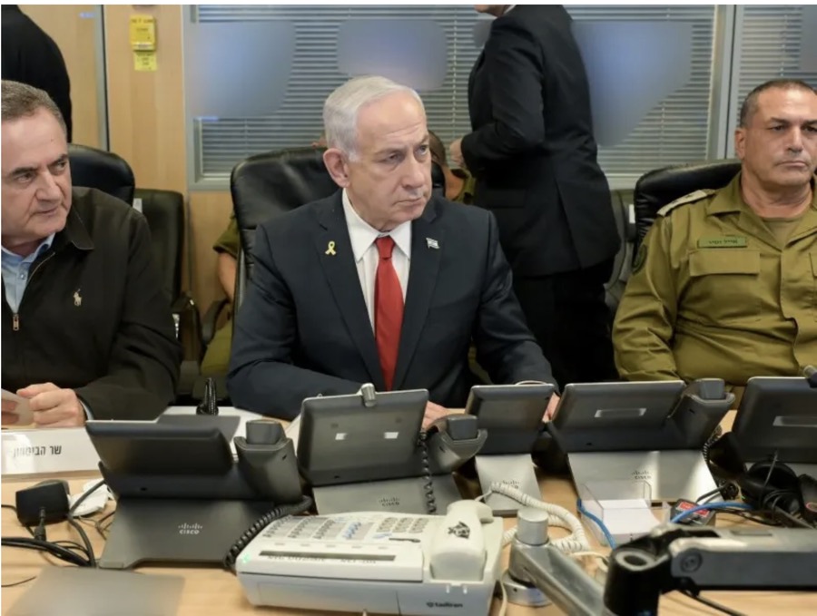 Israeli Prime Minister Benjamin Netanyahu seated at a table with Cisco IP phones during a military briefing